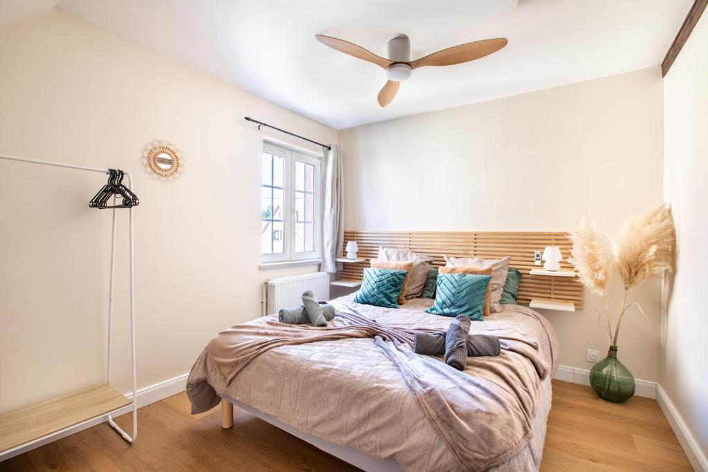 a bedroom with a large bed with blue pillows at Gîte Bretzel et Grappe in Ingersheim