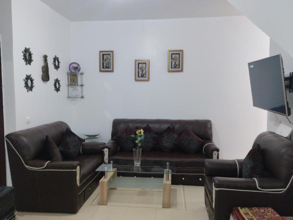 a living room with two leather couches and a coffee table at Dar Yasmine 2 in Ifrane