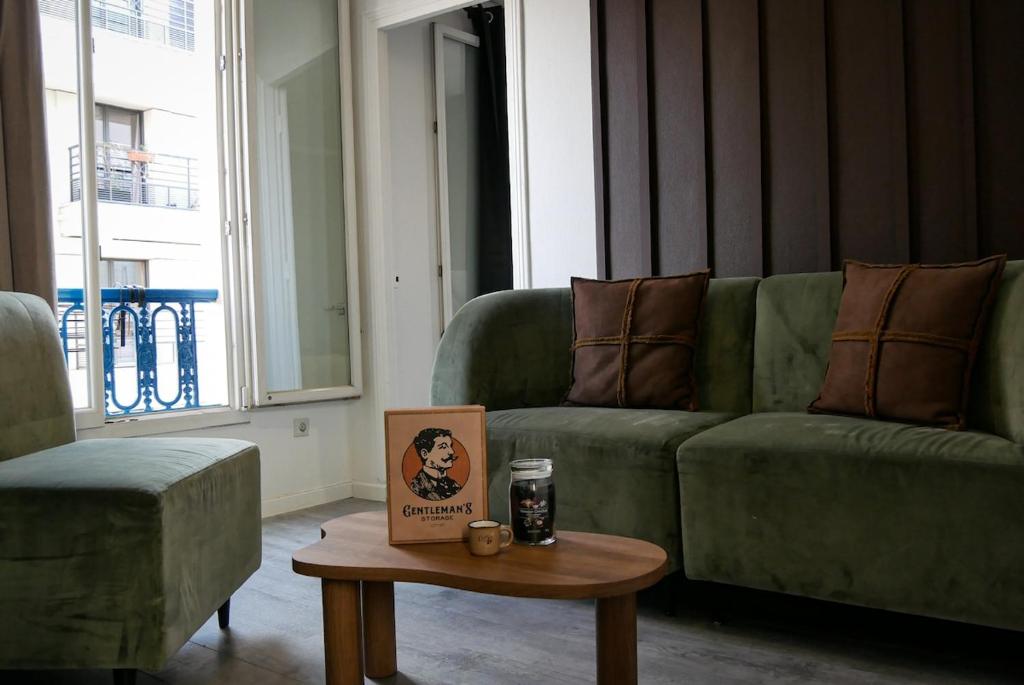 a living room with a green couch and a coffee table at Chocolat Paris, Cozy apartment in Levallois-Perret