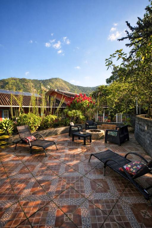 a patio with chairs and tables and mountains in the background at Nina-Flor Pousada Lumiar in Lumiar