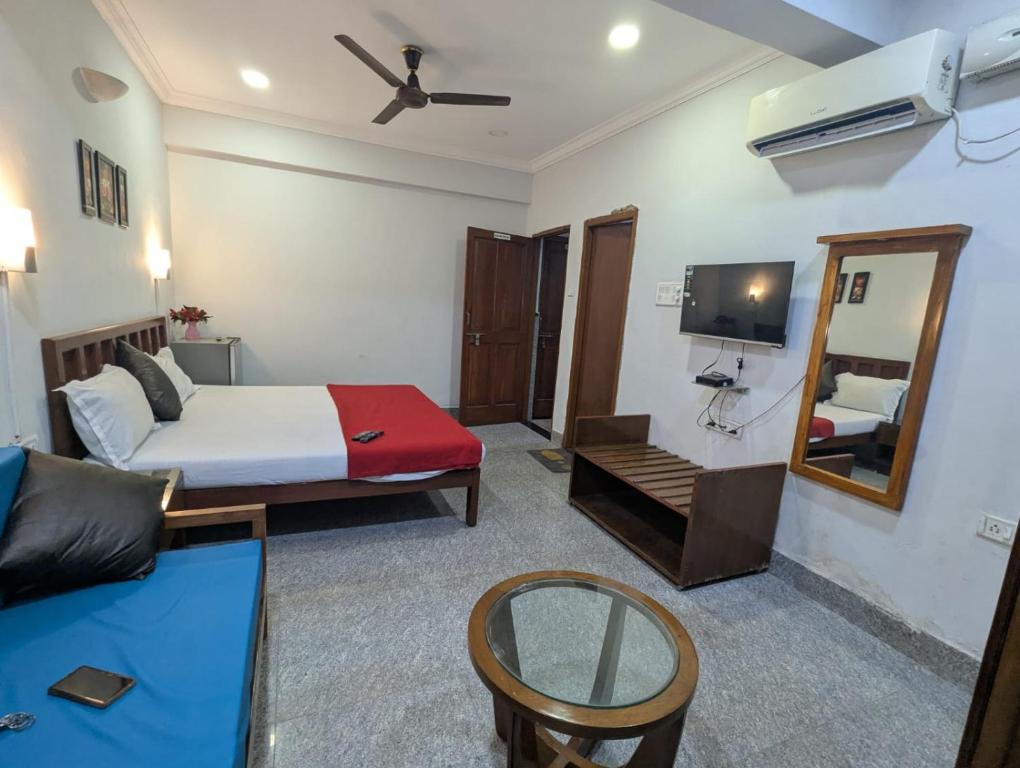 a hotel room with a bed and a mirror at Pavitra Beach Home in Baga