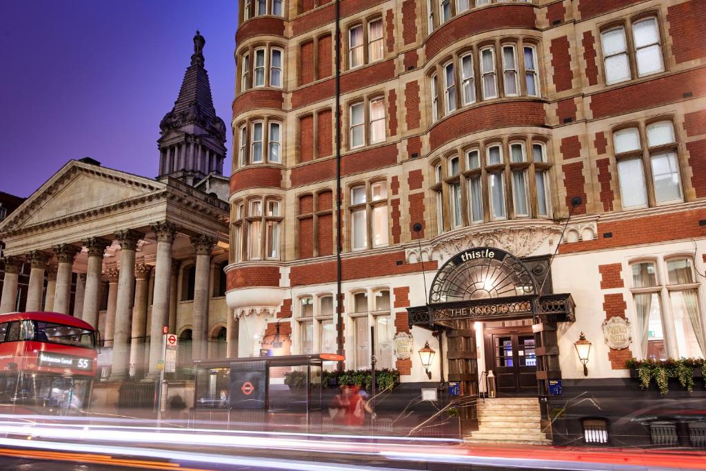 a building on a street with a bus in front of it at Thistle London Holborn in London