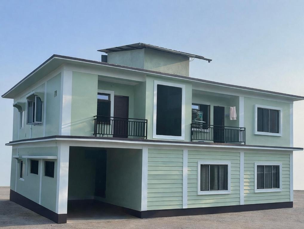 a green house with a balcony on top of it at JAGAT HOUSe in Phagu