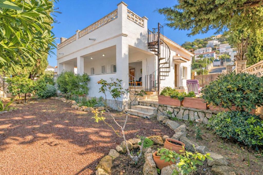a white house with a garden in front of it at Apart-rent Casa Grecs 2029 in Roses