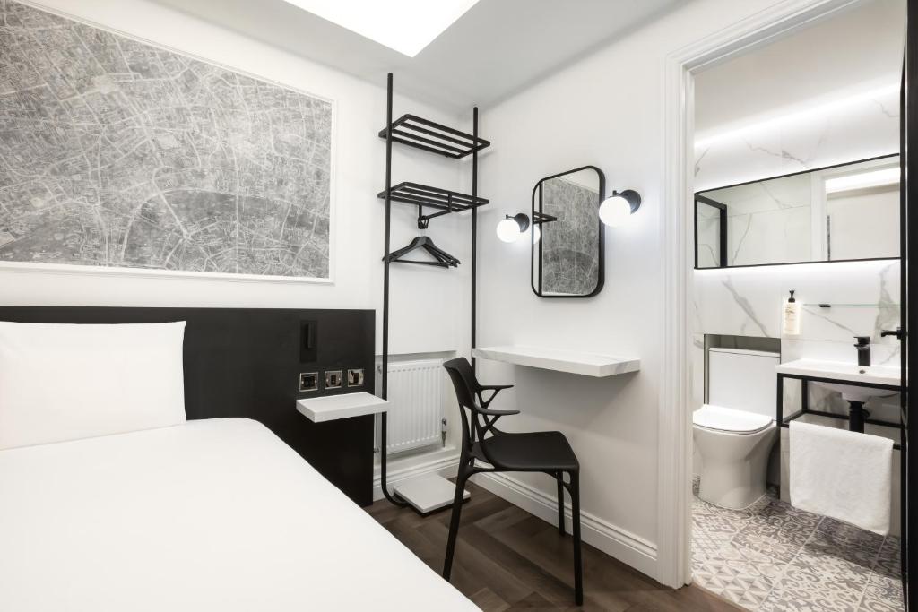 a bedroom with a bed and a desk and a chair at STG Hotel Oxford Street - formerly St Giles London Hotel in London