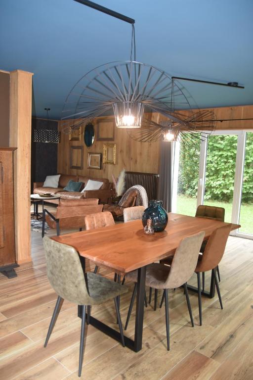 a dining room with a wooden table and chairs at La petite maison en Ardenne in Marche-en-Famenne