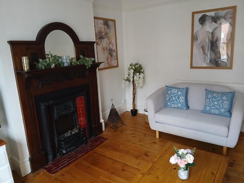 a living room with a couch and a fireplace at Spacious 4 Bedroom House, Garden, Nr Ipswich Town Centre with hot tub in Ipswich