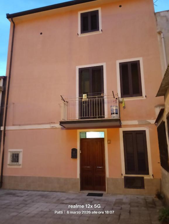 a building with a balcony and a door at Vico Girone in Patti