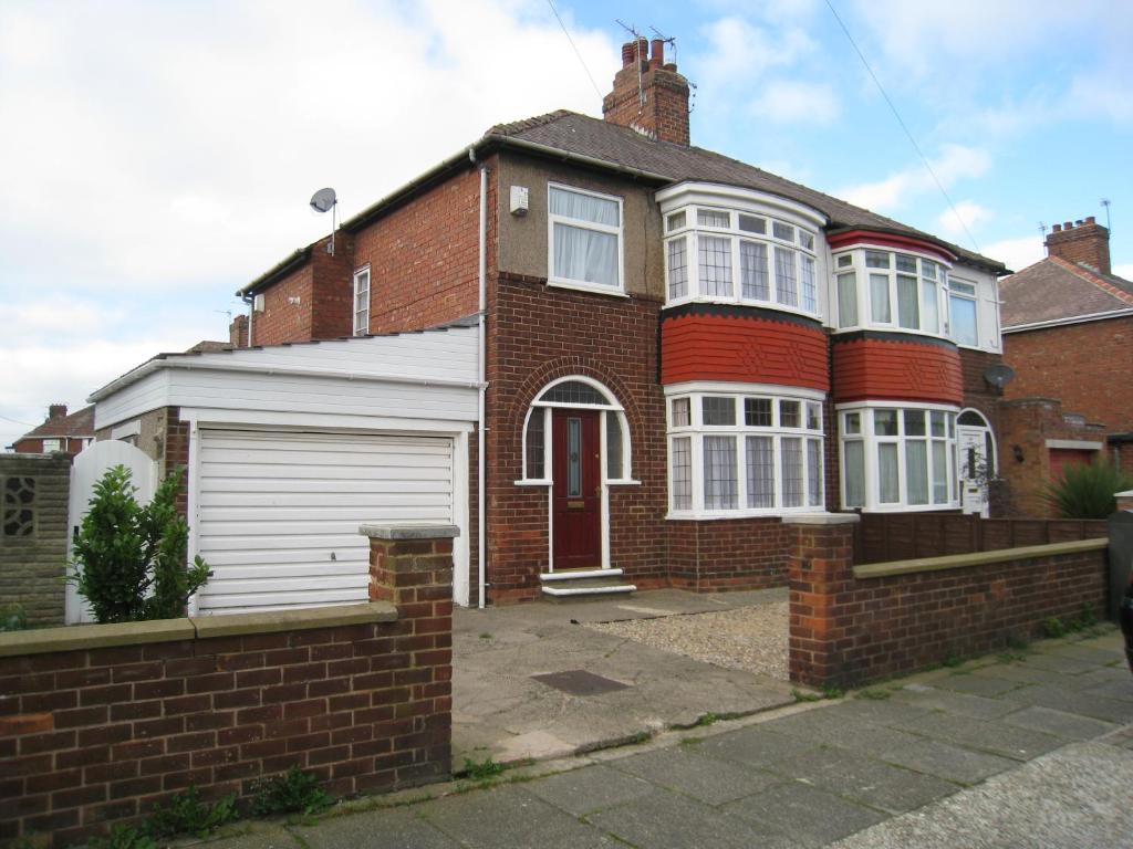 a red brick house with a white garage at Collins Avenue in Norton