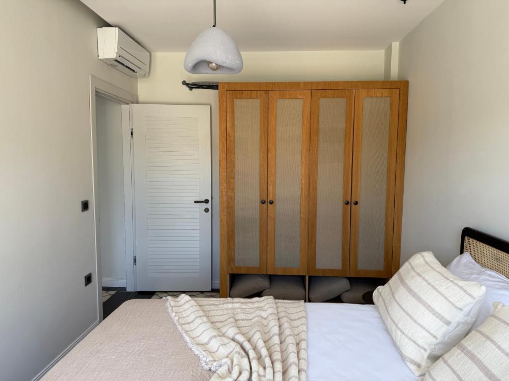 a bedroom with a bed with a wooden cabinet at Kırmızı Bağ Resort in Kuscular