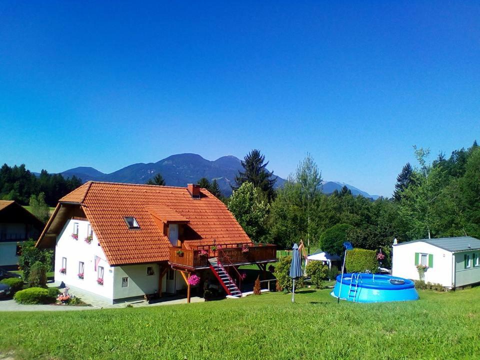 a house with a red roof on a field at Apartment Rozika in Slovenj Gradec