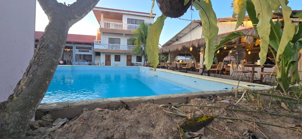 a swimming pool in a resort with tables and chairs at Calamianes Homestay in Coron