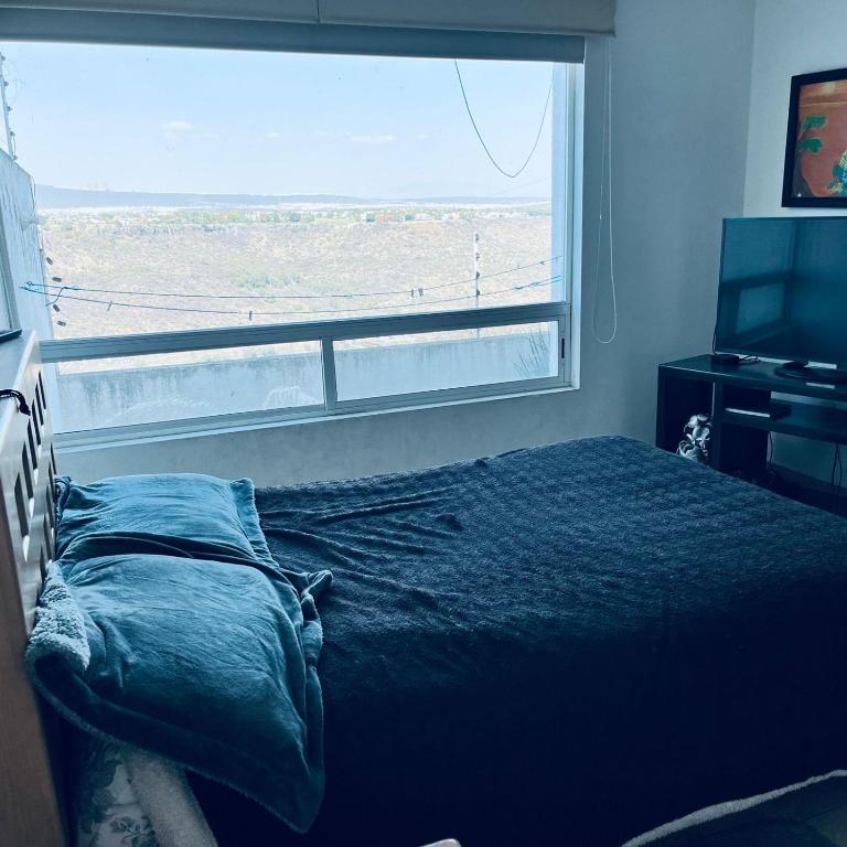 a bedroom with a bed and a large window at Cuarto con linda vista in Hércules
