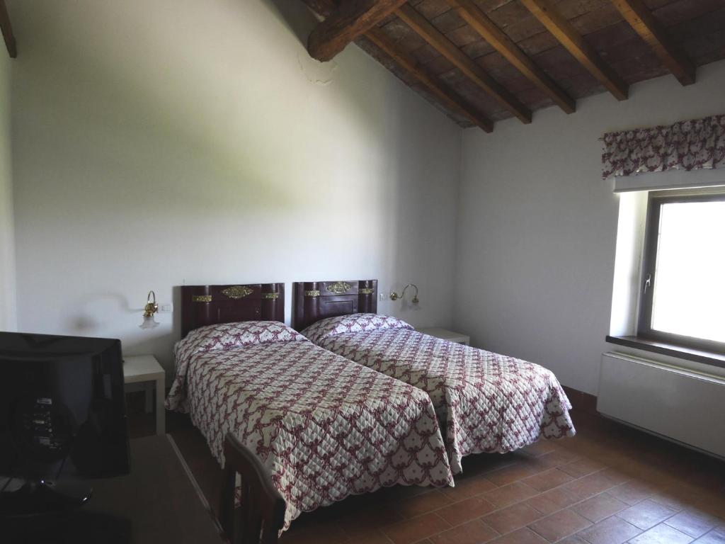 San Colombano al LambroにあるAgriturismo San Brunoのベッドルーム1室(ベッド2台、窓付)