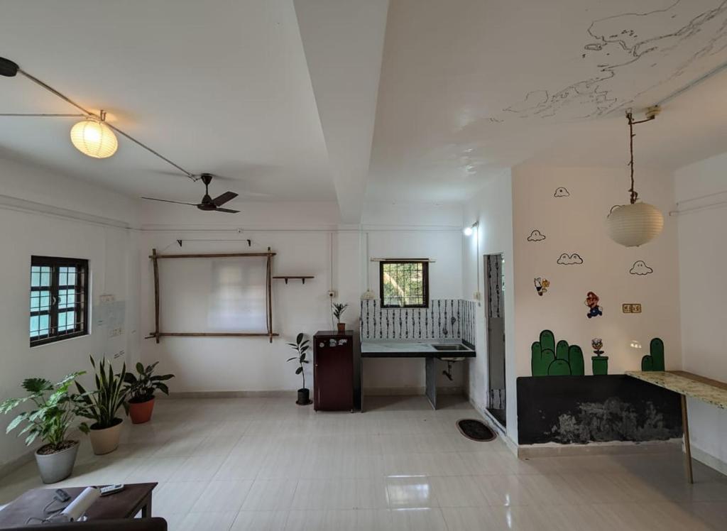 a room with a table and a chalkboard on the wall at House 21 - Mid in Querim