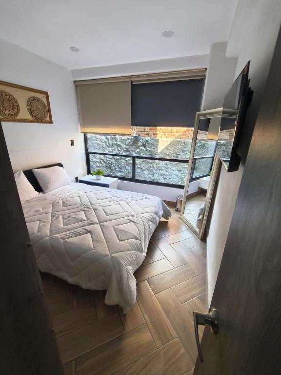 a bedroom with a bed and a large window at Downtown Historic Area Modern and Comfortable in Puebla