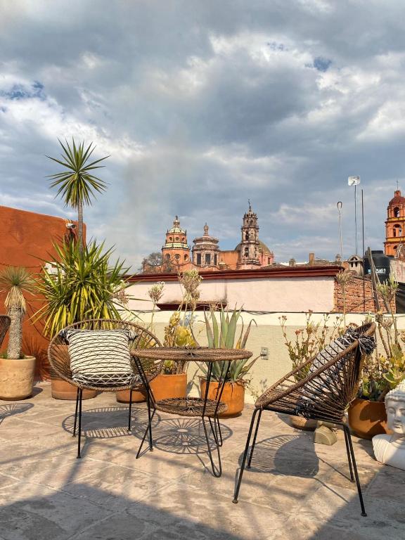 a patio with chairs and potted plants on a roof at Casa H in San Miguel de Allende