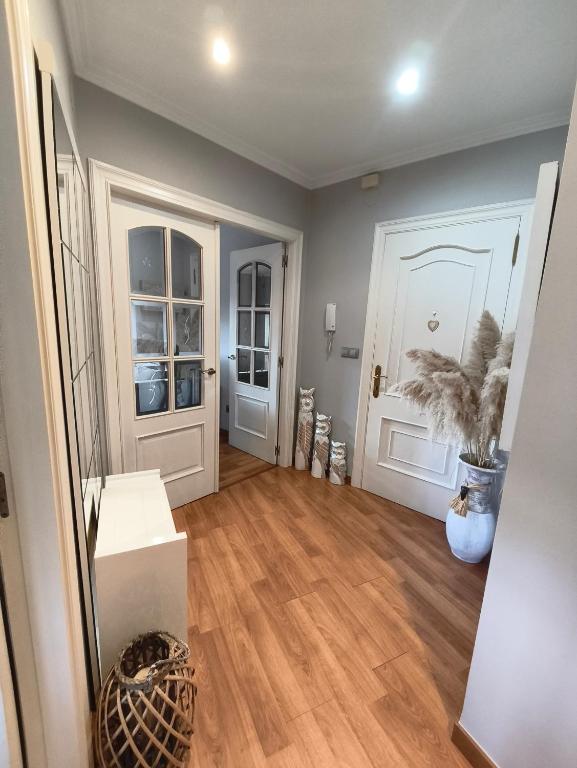 a living room with a hardwood floor and white doors at Curros in Ponte Do Porto