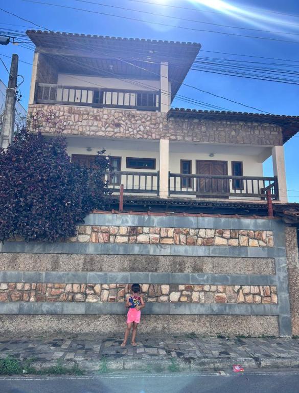 a little girl standing in front of a house at Casa Marron in Anchieta