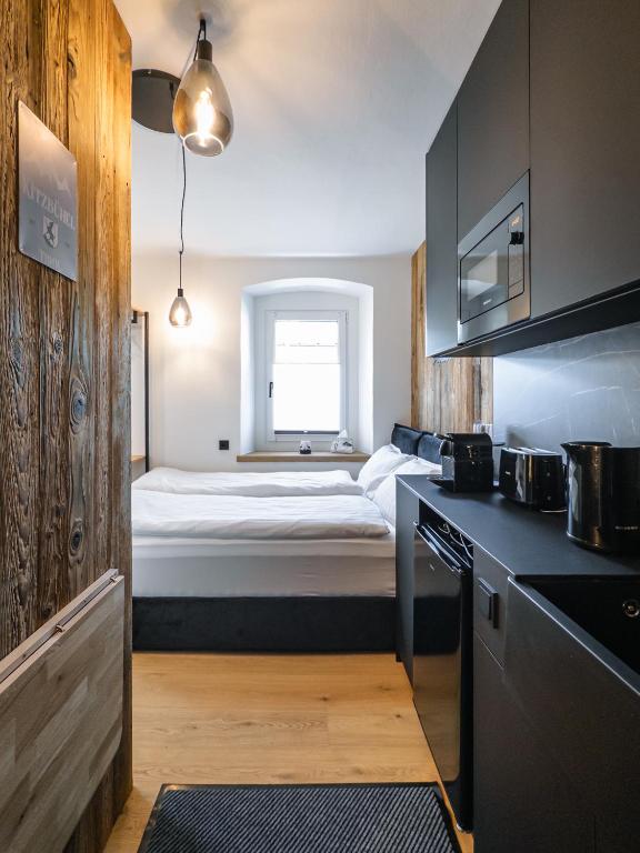 a kitchen with a bed in the middle of a room at Kitz Alpine Apartments - City Center in Kitzbühel