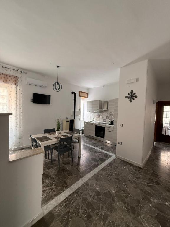 a living room with a table and a kitchen at Carmen House in Bernalda