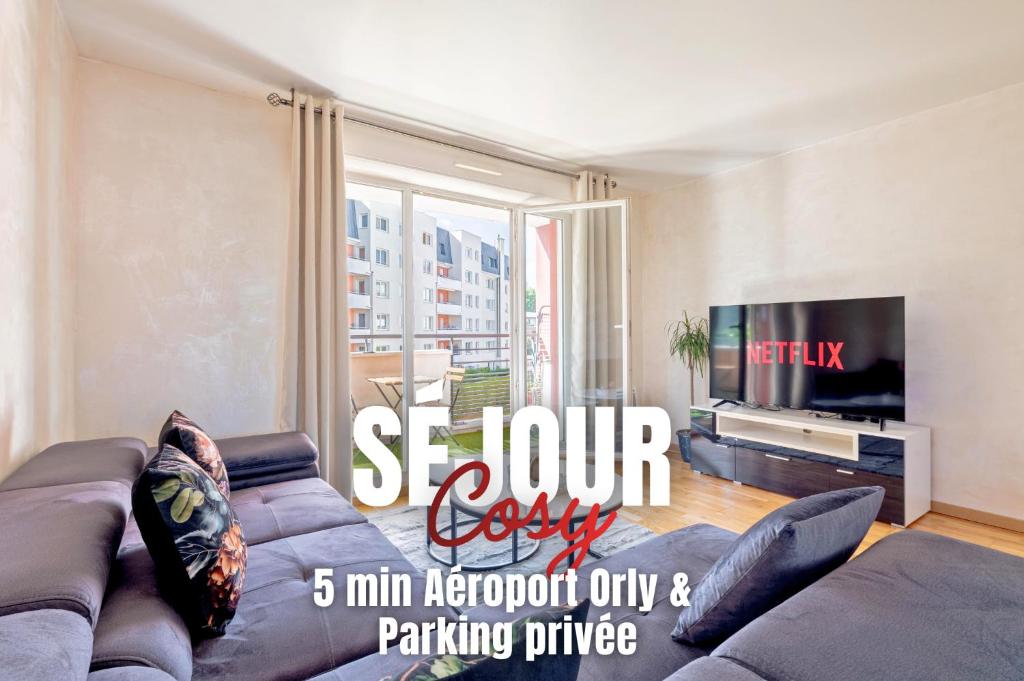a living room with a couch and a tv at Séjour Cosy - 5 min Aéroport Orly - Parking Privée & Terrasse in Orly