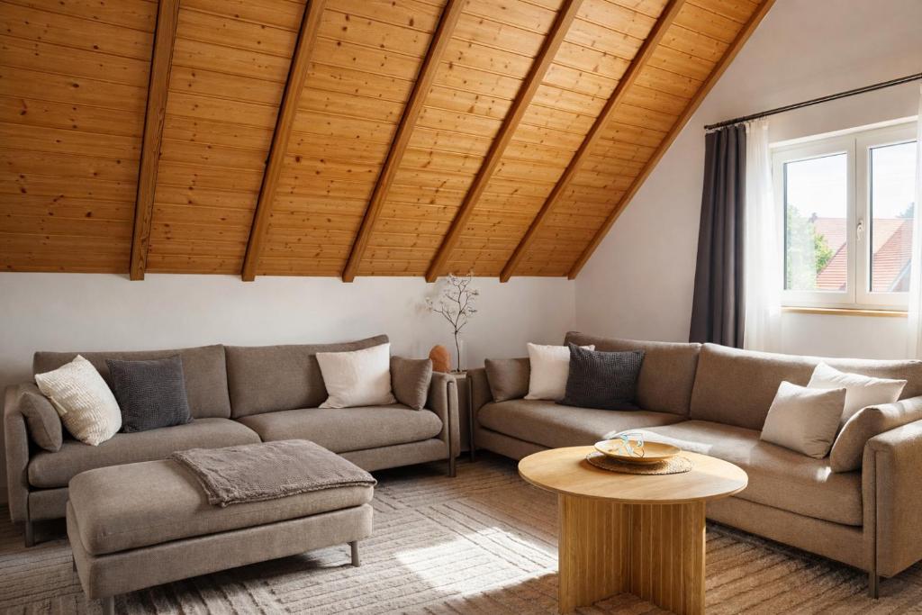 a living room with two couches and a table at Haus am Südfrüchtegarten in Rhodt unter Rietburg