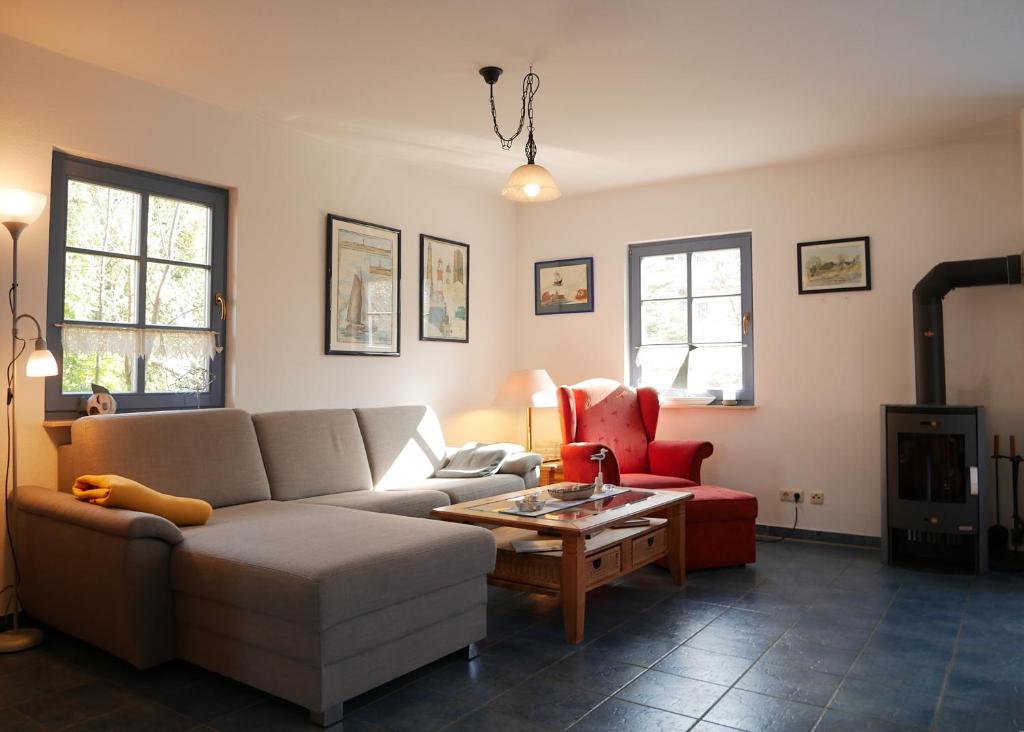 a living room with a couch and a red chair at Fini in Am Schwarzen Busch