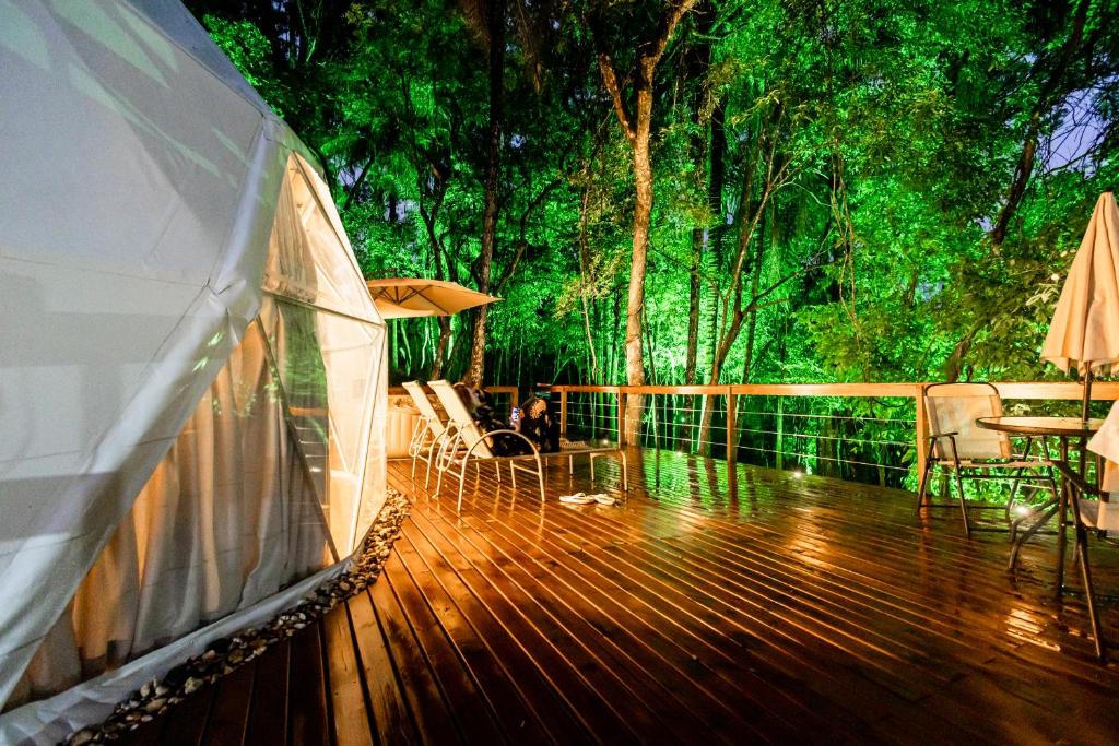 a wooden deck with chairs and an umbrella at Refúgio Bela Cabanas in Imaruí