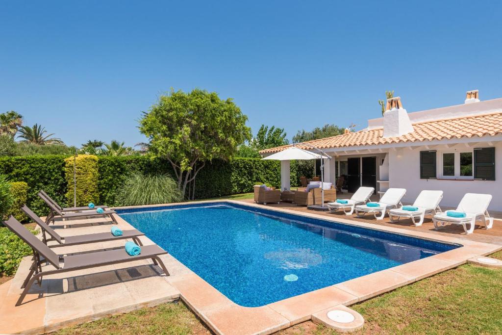a swimming pool with lounge chairs and a house at Villa Sirena - Cap den Font in Binisafua