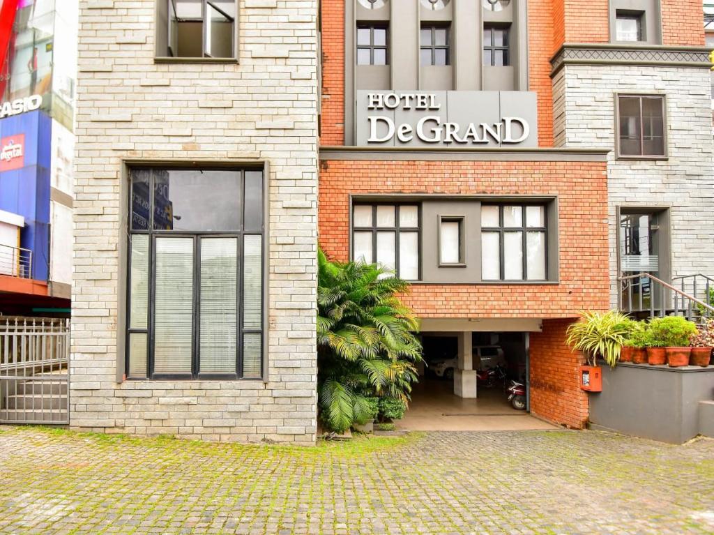 a brick building with a sign for a home de grand at Hotel De Grand Malabar in Kozhikode