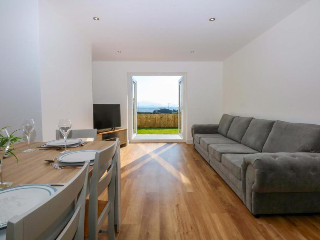 a living room with a couch and a table at Golygfa in Bodorgan