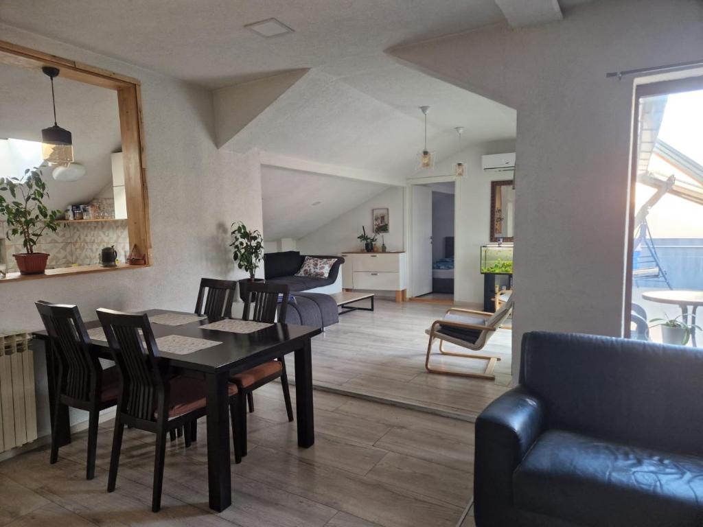 a dining room and living room with a table and chairs at Apartman Gradina in Doboj