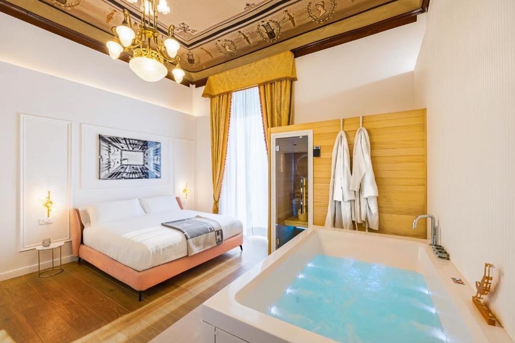 a bedroom with a bed and a tub in a room at Themis Toledo - Private Spa Apartment in Naples