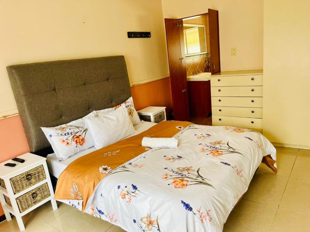 a bedroom with a bed with a floweridered comforter at Mestil Guesthouse in Hoheizen