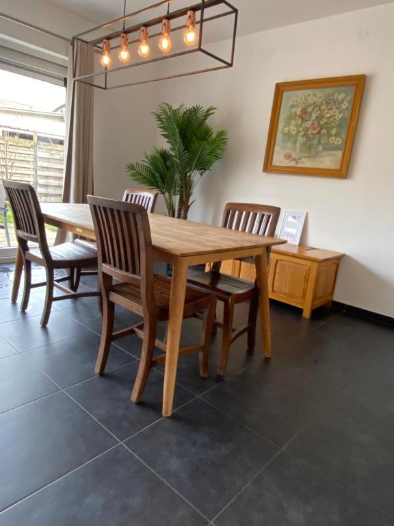 a dining room with a wooden table and chairs at Woning met 4 slaapkamers in Zelzate