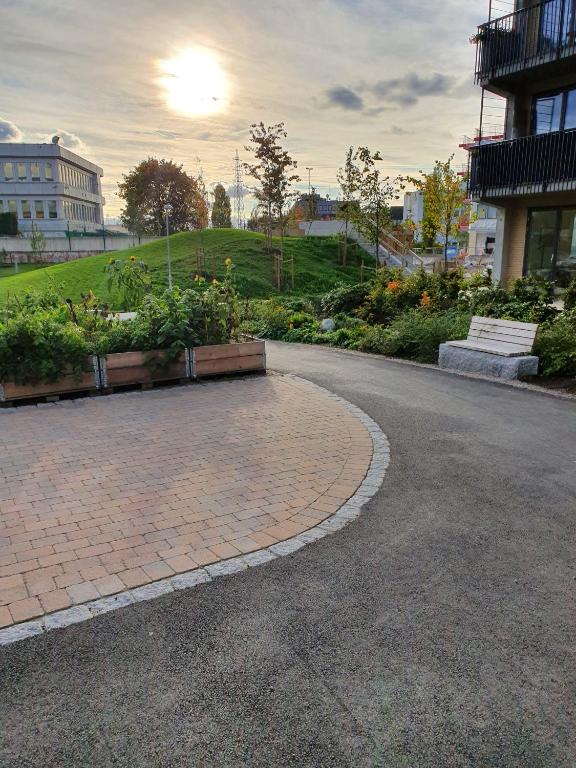 a brick road with a bench and flowers in a park at Ulven Paradise in Oslo