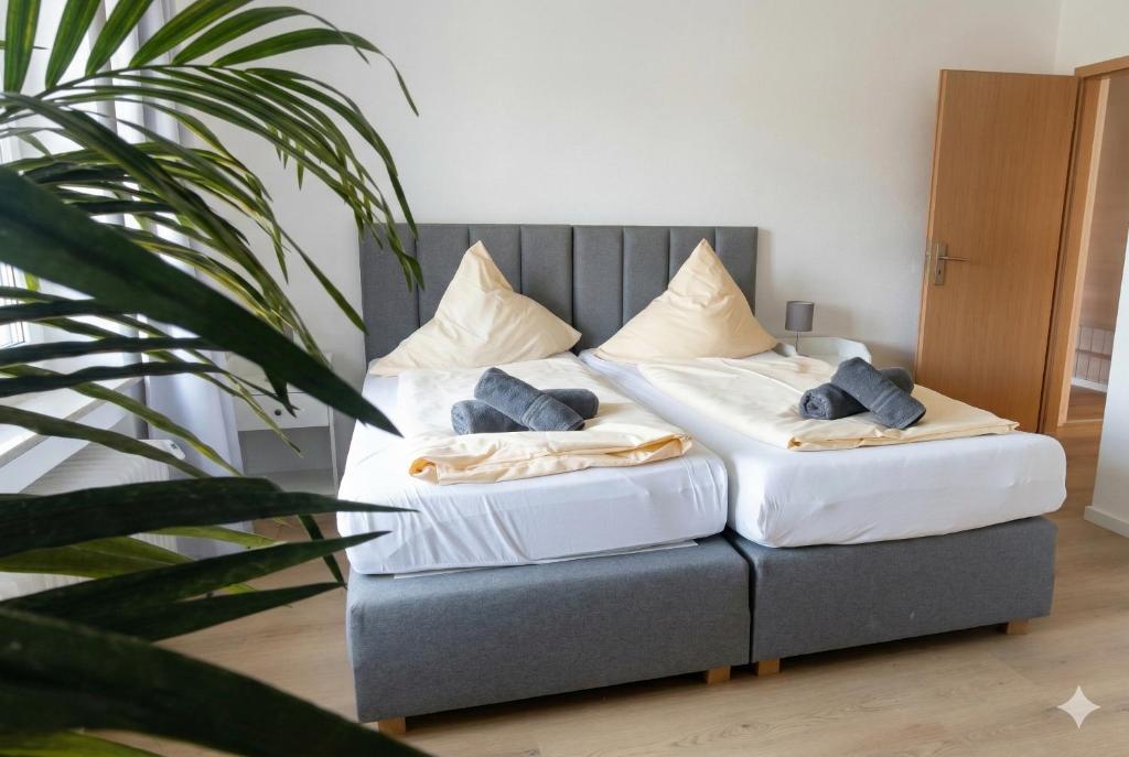 a bed in a room with two pillows on it at Aviva ANKERPLATZ - Familien-Oase mit Gartenterrasse und 2 Schlafzimmern in Bodman-Ludwigshafen