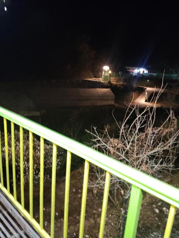 a flooded street at night with a yellow railing at Nanda devi hotel in Mussoorie