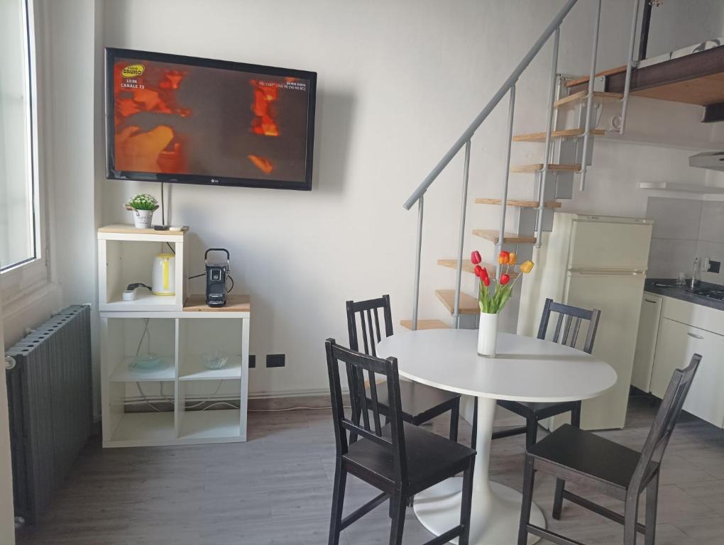 a dining room with a table and chairs and a tv on the wall at Casa Maria - next Milano,Como, Varese in Caronno Pertusella