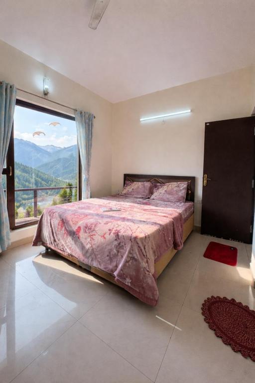 a bedroom with a large bed and a large window at Namya Villas in Bhīm Tāl