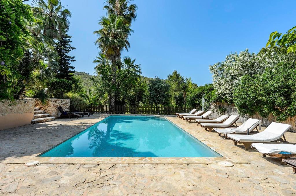 a swimming pool with lounge chairs and a resort at Ca Na Ramona - Finca with Pool Santa Eularia in Santa Eularia des Riu