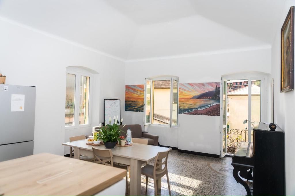 a dining room with a table and chairs and windows at Hostel Bosmi Bed&Language Liguria in Sori