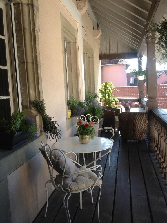 a patio with a table and chairs on a porch at Le BALCON DU PRINCE in Montbéliard