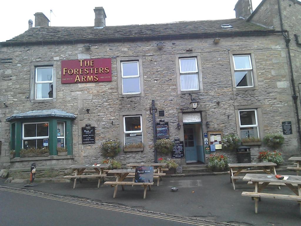 a stone building with picnic tables in front of it at The Foresters Arms in Grassington