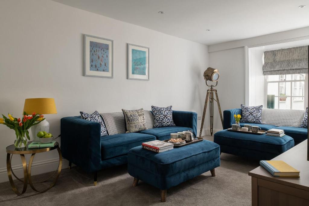 a living room with blue couches and a table at Tides Door in Dartmouth