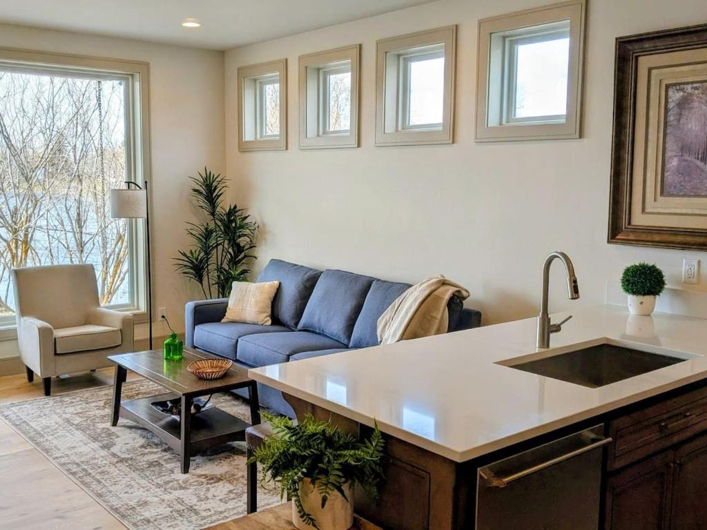 a kitchen and living room with a blue couch at Henrys Fork Suites Suite One in Saint Anthony