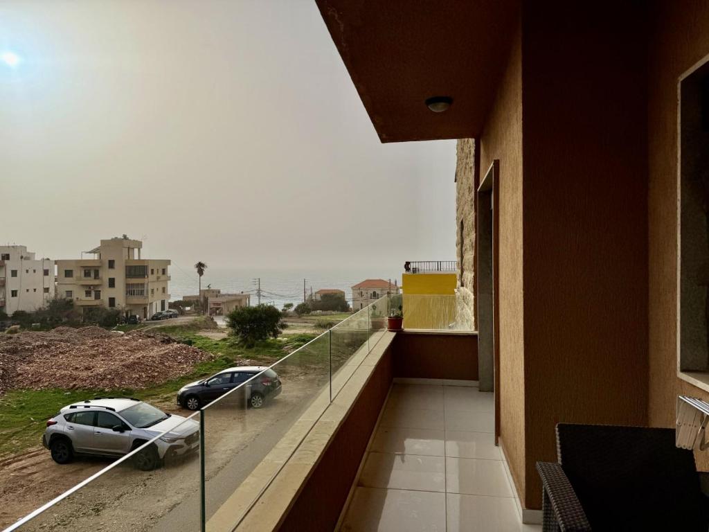 a balcony with a view of two cars on a street at Les Palmiers Kfar Aabida in Fad‘ūs
