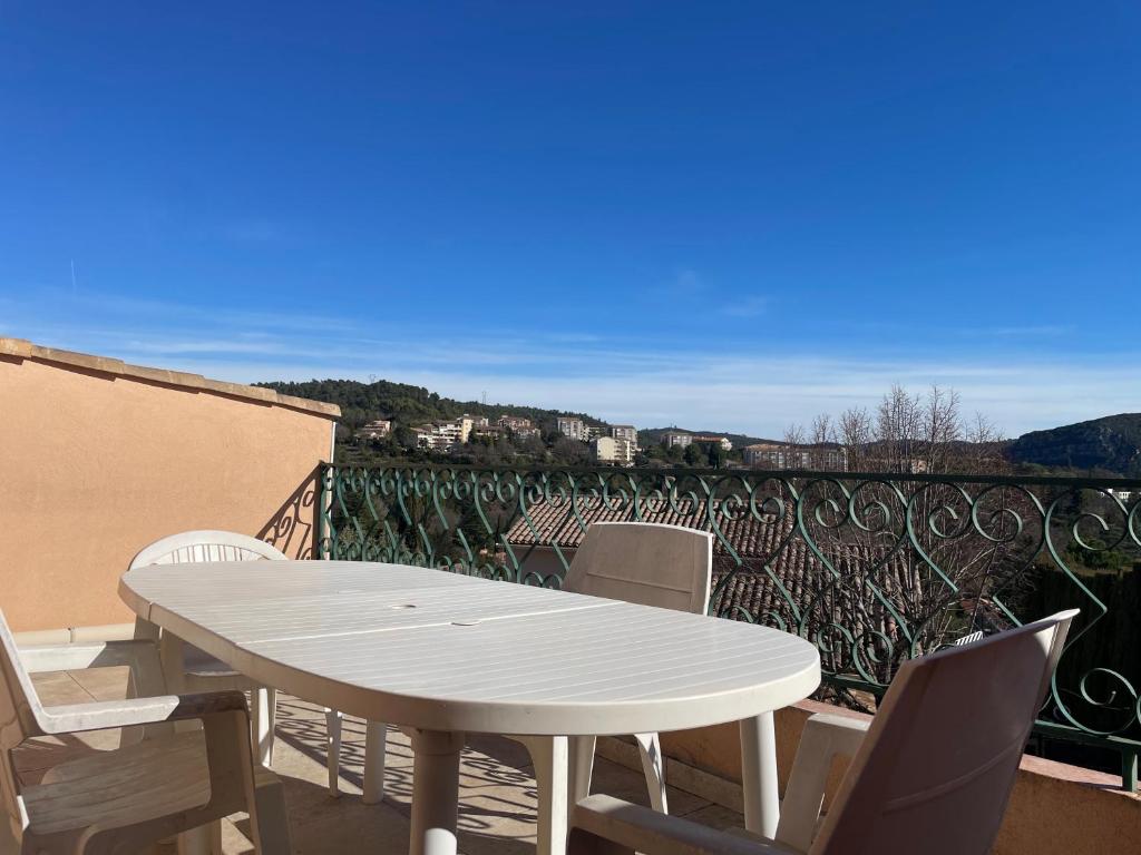 a white table and chairs on a balcony at L'Écrin de Sauge- jolie Terrasse in Gréoux-les-Bains