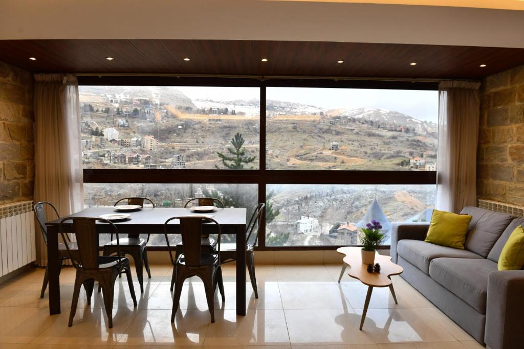 a living room with a table and a couch at Aspen - Duplex 1-BR in Faraya in Fārayyā